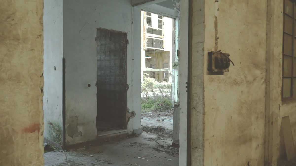 Il corridoio dell&rsquo;edificio abbandonato, vuoto: l&rsquo;inquadratura che apre il video