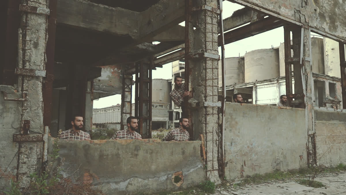 Sei cloni dello stesso performer, in pose diverse fra le rovine