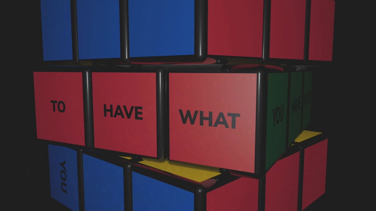 Un cubo di Rubik in 3D, con una frase motivazionale scritta sulle facce