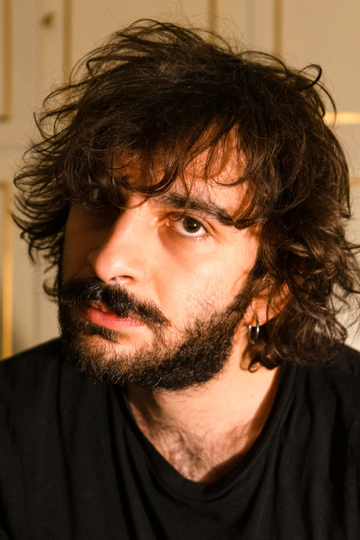 Ritratto in studio, luce calda laterale, sfondo di boiserie chiara e oro